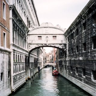 Historic arched bridge spanning Venice canal.
