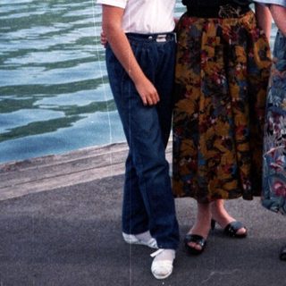 Family posing by a scenic lakefront near mountains.