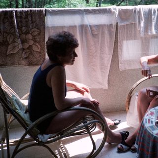 Two women sitting outdoors, engaged in conversation.