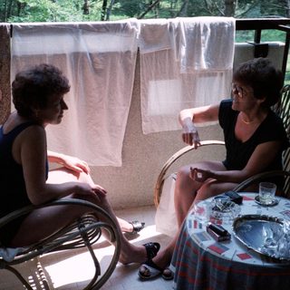 Two women sitting outdoors, engaged in conversation.
