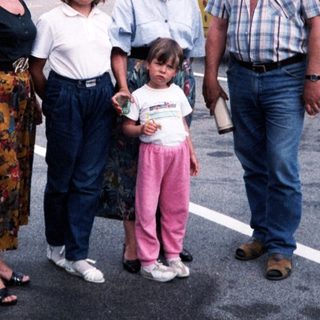 Family posing near mountainous area with bus.