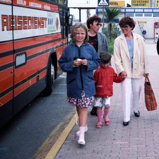 Family walking near coach with "Resident NV" label.