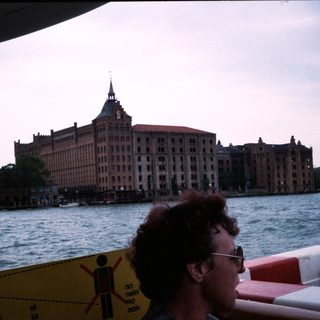 Large historic building by waterfront, viewed from boat.