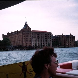 Large historic building by waterfront, viewed from boat.
