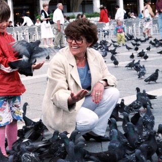 A woman and child feeding pigeons in St. Mark's Square.