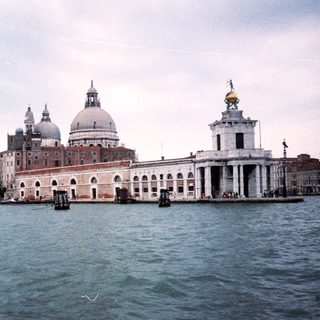 Venetian waterfront with historic basilica and sailing ship.