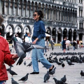 Two children feeding pigeons in St. Mark's Square.