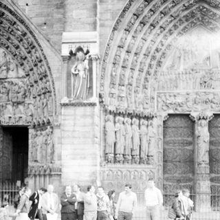 Group of people standing outside historic cathedral facade.
