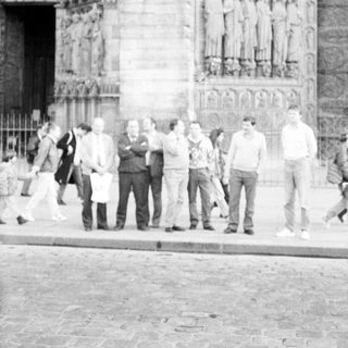 Group of people standing outside historic cathedral facade.
