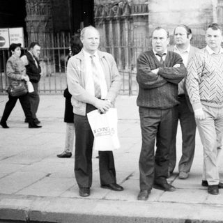 Group of men posing outside historic cathedral.