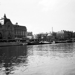 Historic train station by waterfront cityscape.
