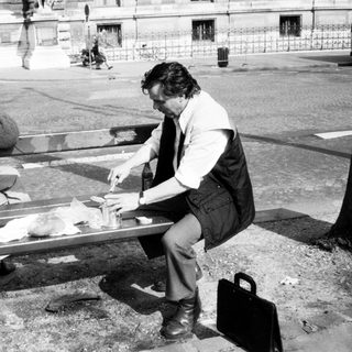 Two people sharing a meal outdoors on a bench.