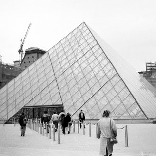 Iconic glass pyramid at Louvre Museum entrance.