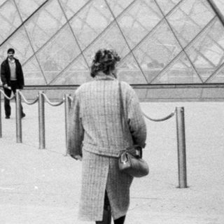 Iconic glass pyramid at Louvre Museum entrance.