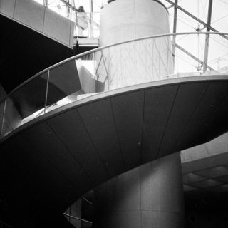 Modern architectural interior with curved surfaces and glass ceiling.
