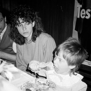 A woman and child eating together indoors.