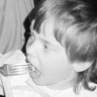 A woman and child eating together indoors.