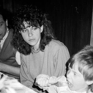 A woman and child eating together indoors.