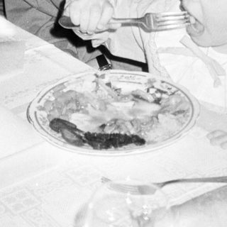 A woman and child eating together indoors.