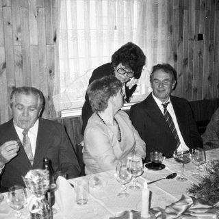 Formal dinner gathering of adults in indoor setting.