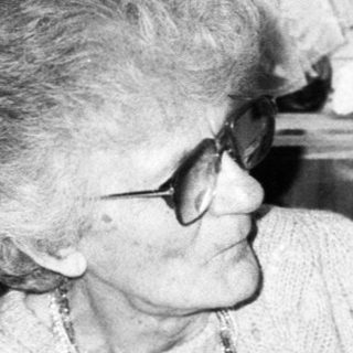 Two elderly people dining together indoors.