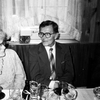 Two elderly people dining together indoors.