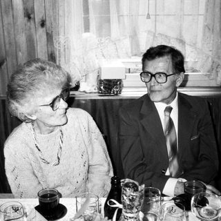 Two elderly people dining together indoors.