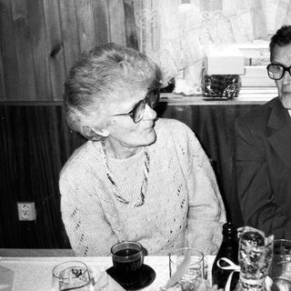 Two elderly people dining together indoors.