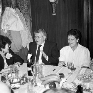 Formal dinner party with guests laughing. Wedding-related event.