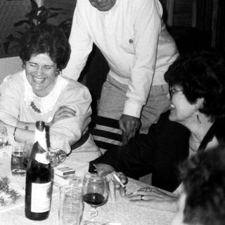 Family gathering enjoying wine and dinner together indoors.