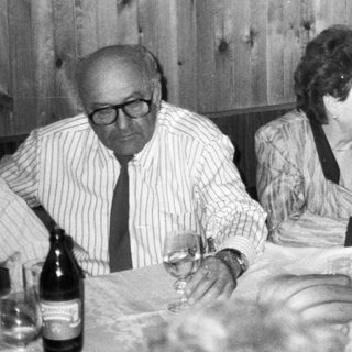 Family gathering enjoying wine and dinner together indoors.