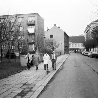 People walking on a quiet urban street in winter.