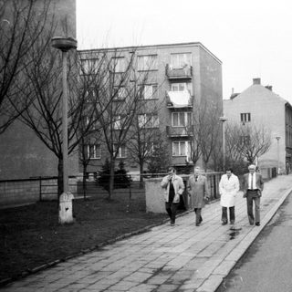 People walking on a quiet urban street in winter.