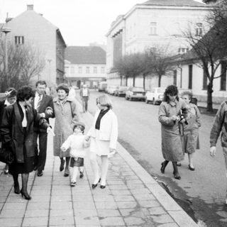 People walking and standing on a city street.