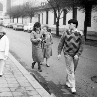 People walking and standing on a city street.