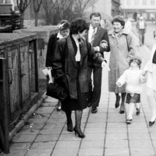 People walking and standing on a city street.