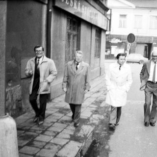 Four people walking together on a city street.
