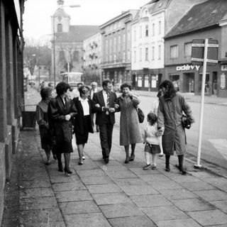 People walking together on a street in a small town.