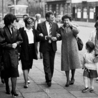 People walking together on a street in a small town.