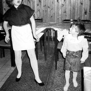 Two children playing with a balloon indoors.