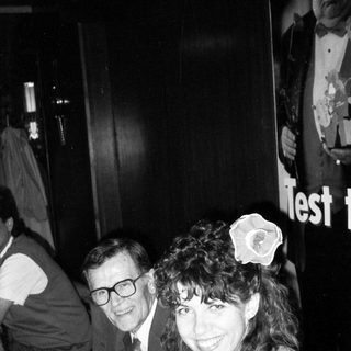 Two people smiling indoors at an event.