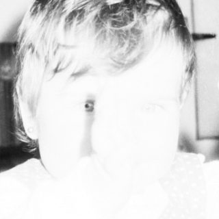 Child playing with large cardboard cutouts indoors.