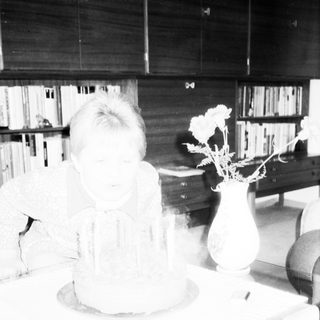 Person sitting on floor with bookshelf reflection.