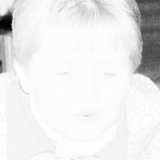 Person sitting on floor with bookshelf reflection.