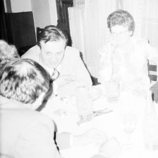 Formal gathering of people seated indoors discussing.