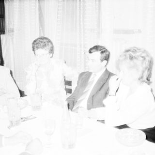 Formal gathering of people seated indoors discussing.