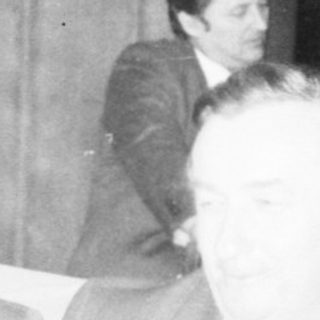 Business meeting or conference with men seated.