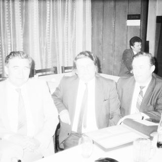 Business meeting or conference with men seated.