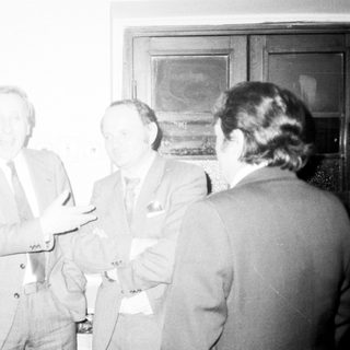 Businessmen engaged in discussion indoors.