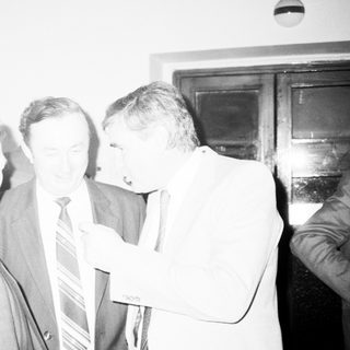 Group of men in formal attire discussing indoors.